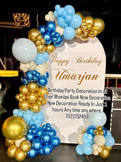 A handsome blue, white, and gold balloon arch on a custom backdrop. This elegant design is perfect for celebrating birthdays for boys and men of all ages.