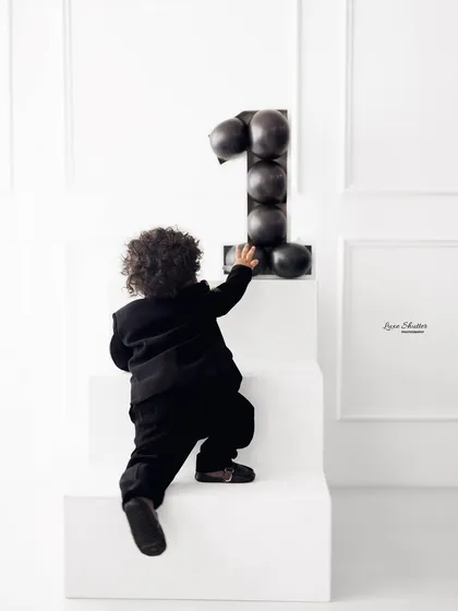 On the move! Capturing the milestone of standing and exploring during a first birthday session.