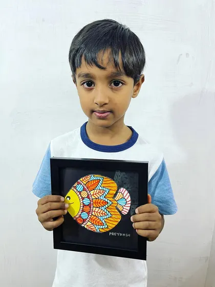 This young artist proudly shows off his completed Madhubani fish. Our summer camps and workshops for kids focus on creating beautiful, finished pieces they can be proud of.