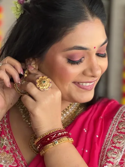 A candid moment of the bride adjusting her earring. This shot provides a great view of the fresh, dewy makeup and the intricate details of her jewelry.