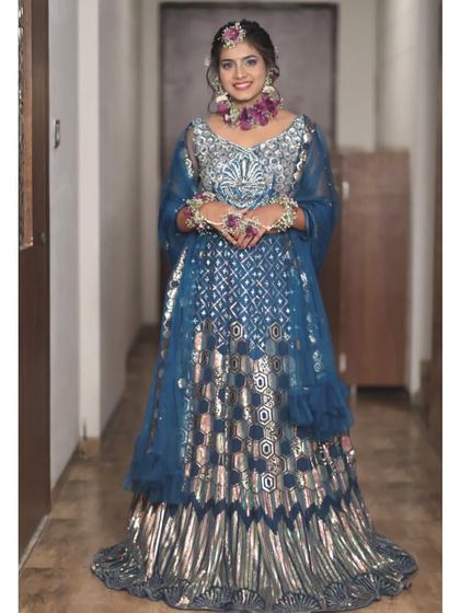 This client chose a unique teal and silver lehenga with a striking geometric pattern. The fresh floral jewellery adds a lovely contrast, making it a great look for a mehendi or haldi ceremony.