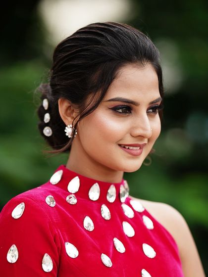 A side profile of Thanvi, showcasing the elegant low bun and flawless makeup I created for her photoshoot.