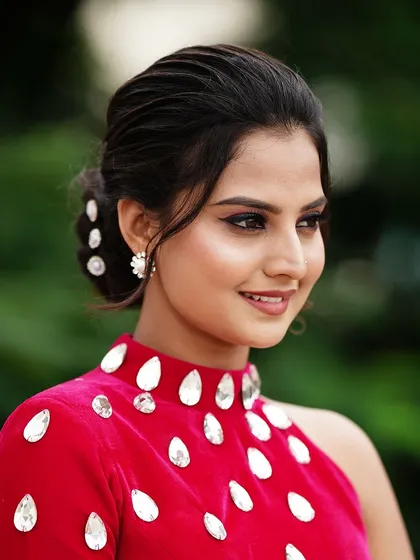 A side profile of Thanvi, showcasing the elegant low bun and flawless makeup I created for her photoshoot.