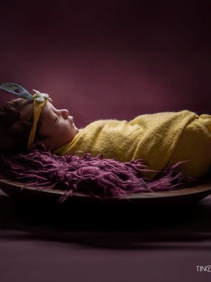The final image in this series, this portrait captures the quiet beauty of a newborn. The simple props and rich colors make it a stunning piece of art.