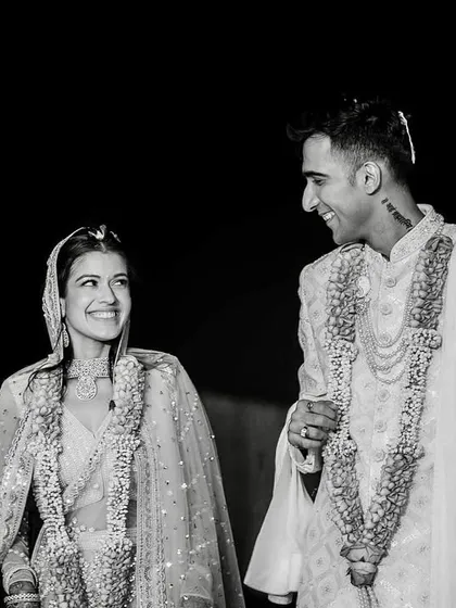 A classic black and white conversion of a candid wedding moment. The lack of color emphasizes the couple's joyful expressions and the genuine connection between them.