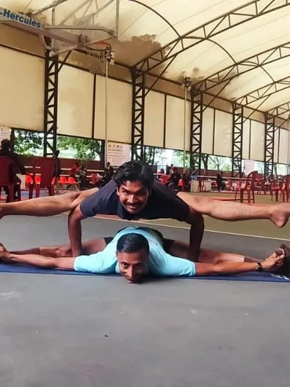 This is a partner variation of Koundinyasana, an advanced twisting arm balance. Practicing with a partner can help deepen the posture and build trust, showing another dimension of yogic practice.