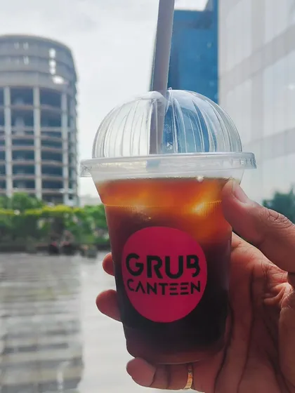 An iced Americano from my canteen, enjoyed against the backdrop of a Noida office park. I make sure to offer refreshing beverages like this to help you power through a busy workday.