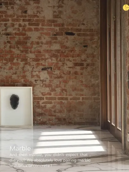 You might not expect to see marble paired with raw brick or concrete, but we love the contrast. Here, the polished marble floor reflects light and adds a touch of refinement that balances the ruggedness of the brick wall.