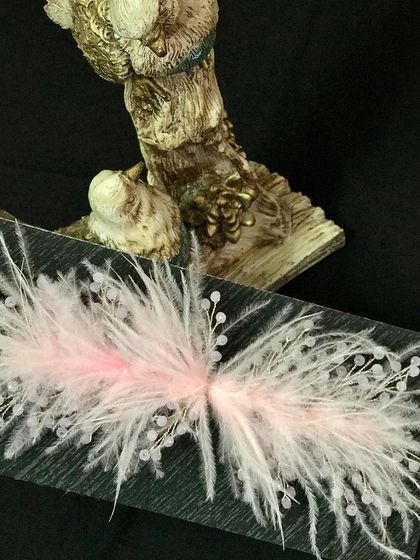 This soft baby pink feather accessory is perfect for a delicate and feminine hairstyle.