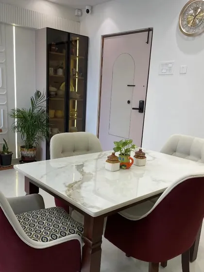A cozy dining nook that feels both elegant and personal. The combination of patterned and solid-colored chairs adds a touch of playful sophistication around the marble-topped table.