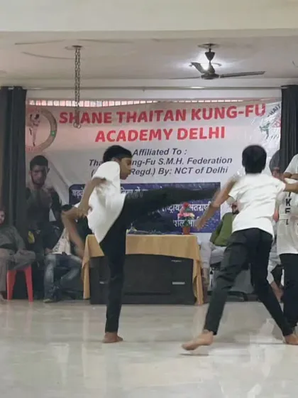 A dynamic action shot from a sparring session. One student delivers a kick while another defends. This is how we test our skills in a live, controlled environment.