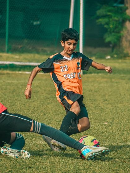 A slide tackle comes in as a player tries to move the ball forward, a moment of decisive defensive action.