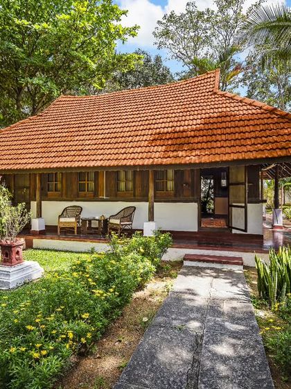 The inviting porch of the Ambara Mana cottage, a perfect spot to relax and enjoy the serene garden views. The traditional architecture promotes natural airflow and a connection to the outdoors.