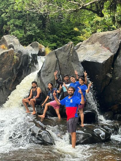 A group enjoying a small waterfall on the Kudremukha trail.