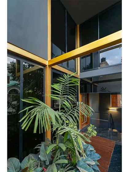 Inside the 'SOL' residence, a courtyard-like space brings nature into the heart of the home. The golden exterior frame continues inward, blurring the boundary between the structure and the interior living areas.