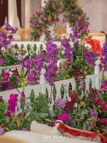The "Garden of Vows" was a picture of elegance. This seating area, nestled within a picket fence overflowing with purple flowers, made every moment feel unforgettable.