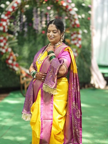 This bride embraced Maharashtrian traditions with grace. Her look in a yellow and purple Nauvari saree is both authentic and elegant.
