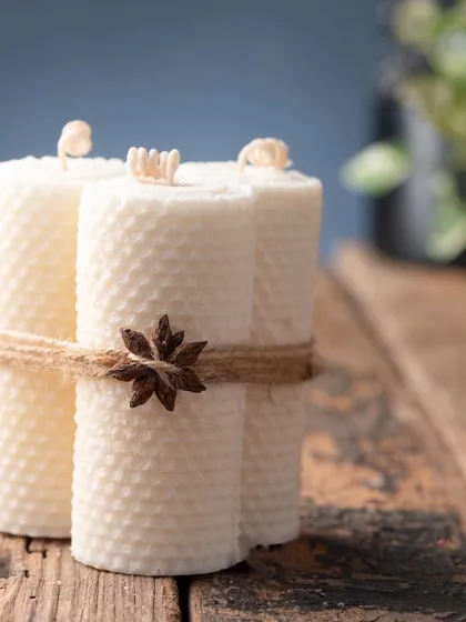 A set of four beeswax pillar candles, tied together with rustic twine and a star anise. The natural honeycomb texture adds a beautiful, organic feel to your decor.