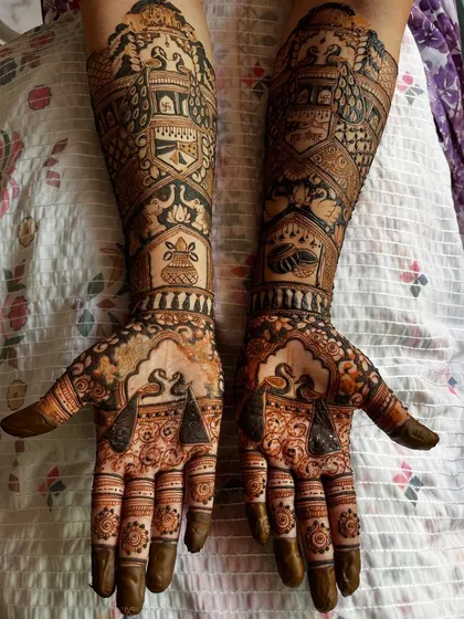 This bridal mehendi is filled with auspicious symbols, including swans, kalash (ceremonial pots), and palace architecture, bringing blessings and beauty to the bride.