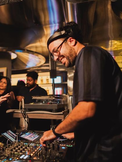 A smiling shot of me at the decks during a vinyl night. Playing records I love for people who appreciate them is one of the best parts of my job.