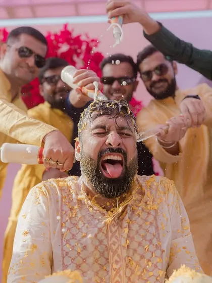 The groom's priceless expression as his friends pour milk over his head during the Haldi.