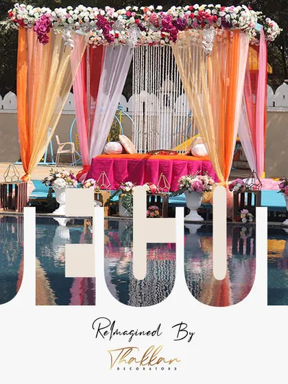 A poolside Mehendi setup in Jaipur, reimagined with vibrant drapes and a comfortable seating area, creating a beautiful reflection in the water.