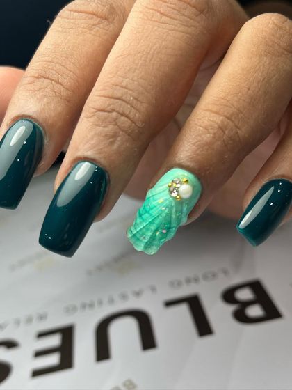 A side view of the gum gel extensions, showing the strength and shape of the square nail. The 3D shell art is sculpted directly onto the nail for a durable, integrated design.