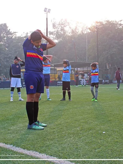 A group of players performs synchronized stretching exercises. Proper warm-ups and cool-downs are crucial for performance and injury prevention.