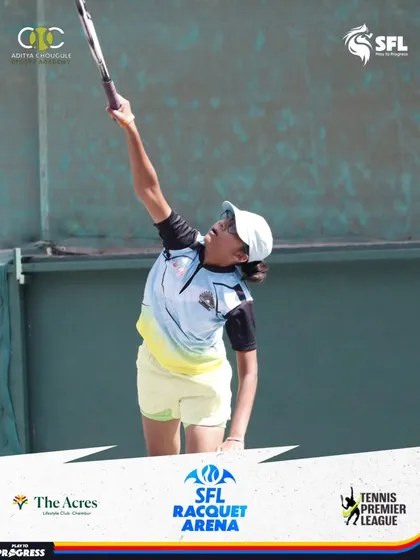 A young girl reaches high for a powerful serve, a critical skill for any aspiring tennis champion. Her form shows dedication and expert coaching.