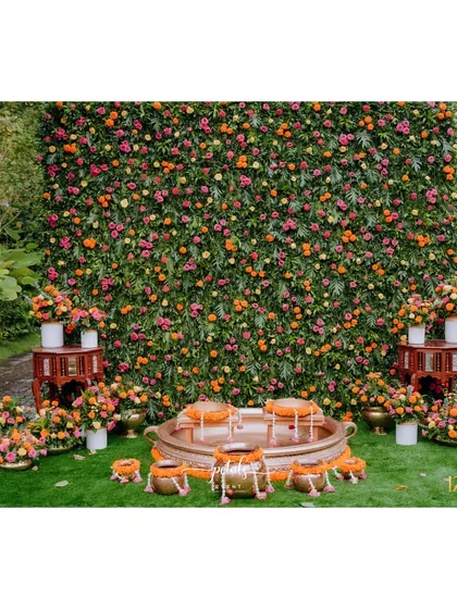 A Haldi ceremony is all about vibrant joy. I created this stunning backdrop, a full wall of colorful marigolds and roses, complemented by traditional brass urulis, to serve as the perfect setting for this happy and sacred ritual.