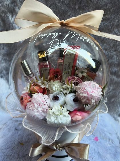 This Mother's Day hamper from our Blooming Garden Collection includes premium hand creams and perfumes nestled among the flowers inside a personalized acrylic balloon. It's a luxurious and pampering gift.