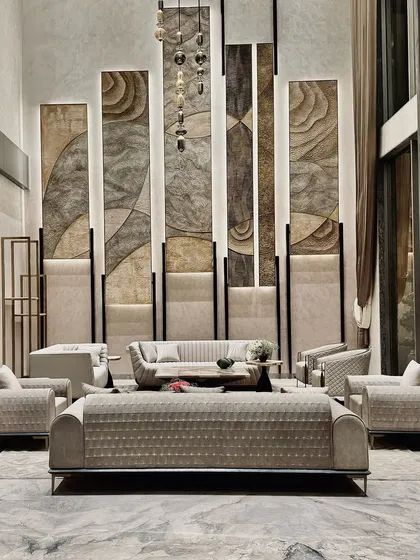 This double-height living room is a study in verticality and texture. We used towering, backlit panels with organic patterns to draw the eye upward, creating a sense of grandeur, while the plush, contemporary sofas arranged for conversation provide a grounded, comfortable core to the space.