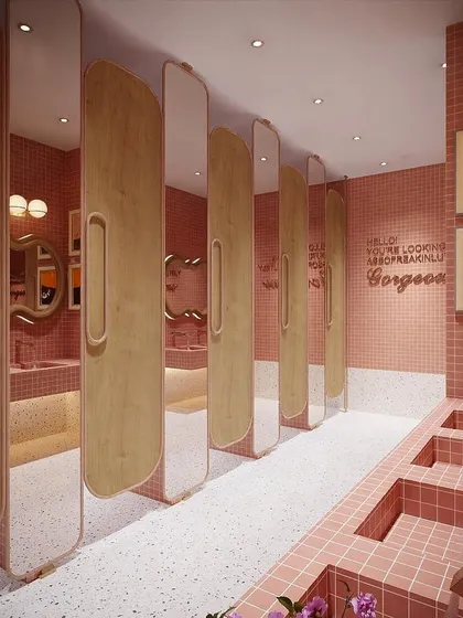 This view showcases the row of washroom stalls, with a positive affirmation in neon lights. I believe every part of an office, including the washroom, should be a thoughtfully designed and uplifting experience.
