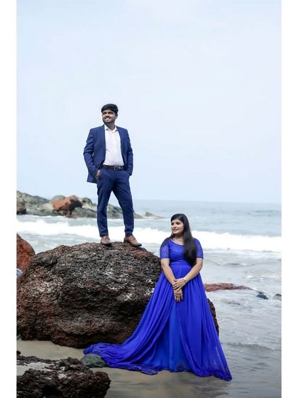 A classic pre-wedding pose by the ocean. The royal blue gown with its long train is an elegant and timeless choice.