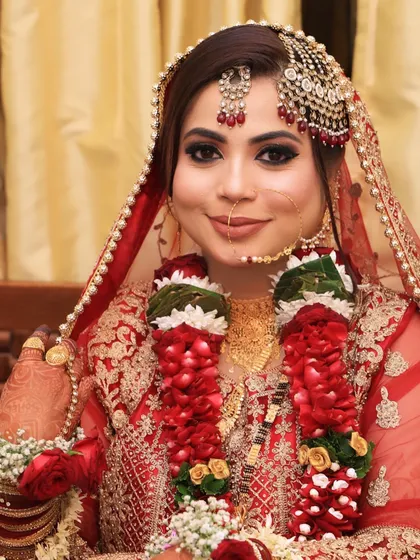 A happy moment with my beautiful Nikkah bride. Adorned with a flower garland, her makeup features a soft smoky eye and a pretty nude-pink lip, making her look radiant and joyful.