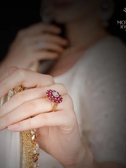 A clearer view of the ruby and diamond floral ring, showcasing its intricate design and vibrant colour against a soft background.