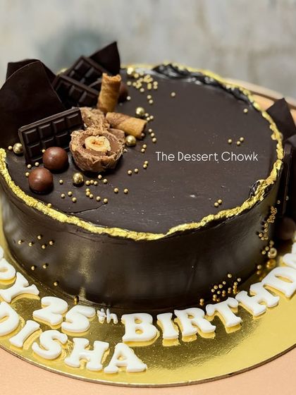 A rich chocolate truffle cake with a "Happy 25th Birthday" message, decorated with Ferrero Rocher and chocolate bars.