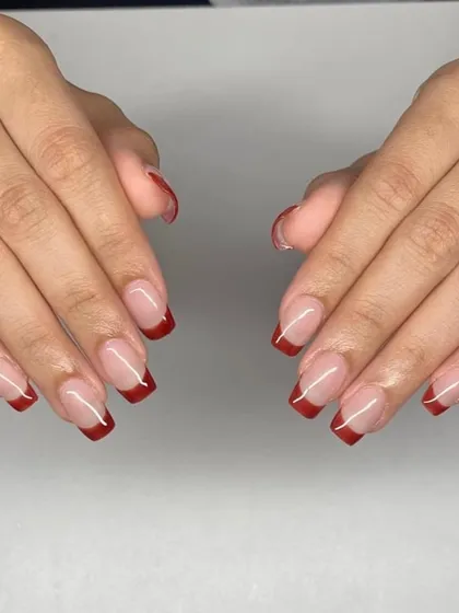 A modern twist with deep red French tips. This design is dramatic and sophisticated, offering a bold alternative to the traditional white tip.