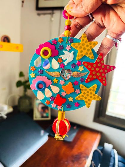 Holding the "Our Angels" memorial hanging. It's a piece I created to help celebrate the bond with our loved ones who have passed on, reminding us to make them proud.