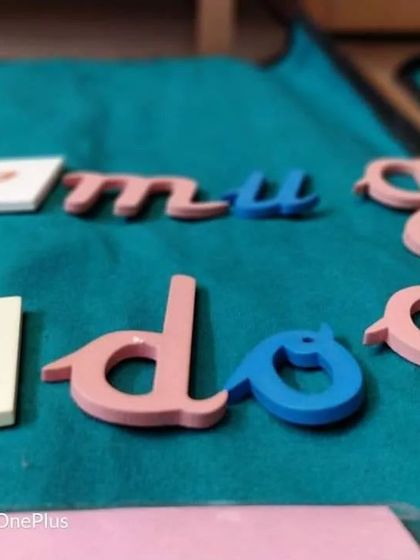 A close-up of the movable alphabet, a key language material. The vowels are blue and consonants are pink (or red) to help children subconsciously differentiate them as they build words.