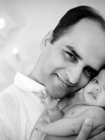 A father's gentle smile as he holds his newborn. This intimate black and white portrait is full of warmth and emotion.