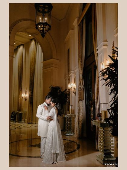 A dramatic and romantic portrait of the couple in a grand, high-ceilinged room, the lighting creating a sense of intimacy and scale.
