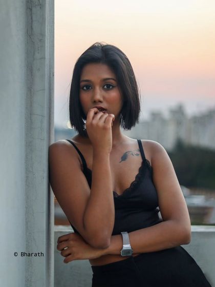 A close-up portrait during the golden hour. The warm light and the city backdrop create a sophisticated and intimate feel.