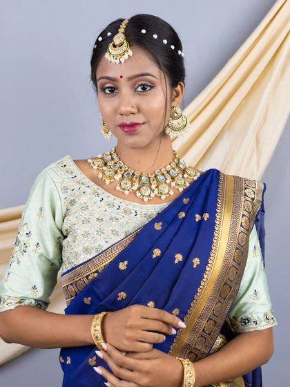 A close-up portrait showing the beautiful temple jewellery and the embroidered mint green blouse that complete this traditional look.