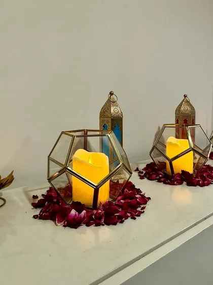 Transforming every nook and corner to match the vibe of the night. Here, we used geometric candle holders and scattered rose petals to add a touch of romance and warmth to a simple ledge.