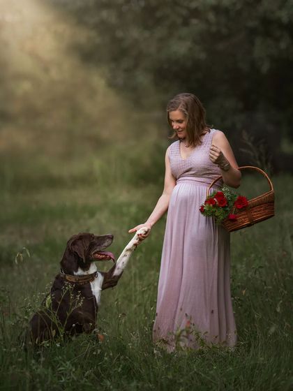 A duplicate of ID 22, this whimsical outdoor portrait of an expecting mother "shaking hands" with her dog in a field of wildflowers is full of charm and playful energy.