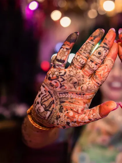 A close-up shot focusing on the intricate design of the bride's mehndi. This image celebrates a beautiful and significant tradition, capturing the artistry that is part of the bridal transformation.