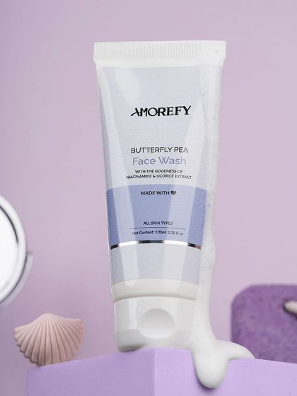 A butterfly pea face wash styled with purple props to match the packaging. A cohesive color palette creates a polished and professional look.