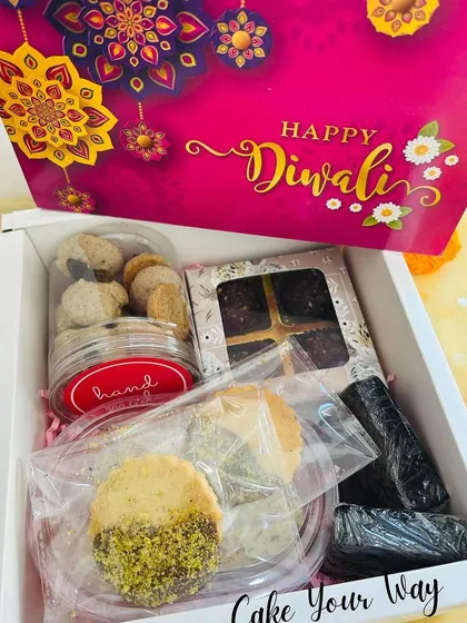 The 'Zayka Diwali Box' is a perfect blend of sweet and savory. It contains Oreo Mini Cookies, Pistachio Sable, Italian Pizza Sticks, a Fudgy Brownie, and a Date & Chocolate Foxnut Laddoo.