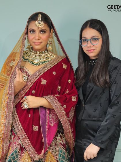Student Work: An accomplished student poses with her model, who is adorned in a rich velvet lehenga. The makeup is perfectly balanced to complement the opulent outfit.